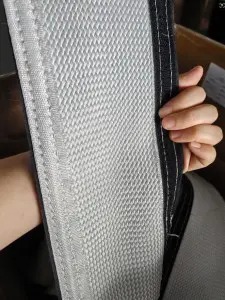 Hand holding an open fiberglass fire sleeve with hook-and-loop edge